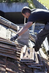 Roofer repairing badly damaged roof