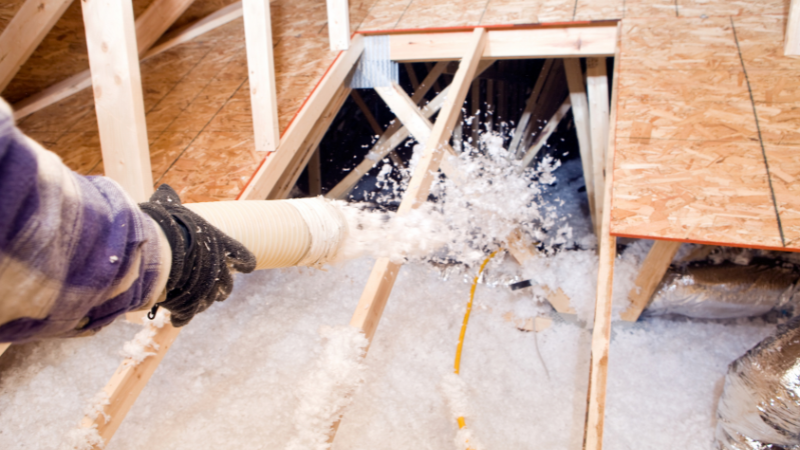 Insulation being blown in attic