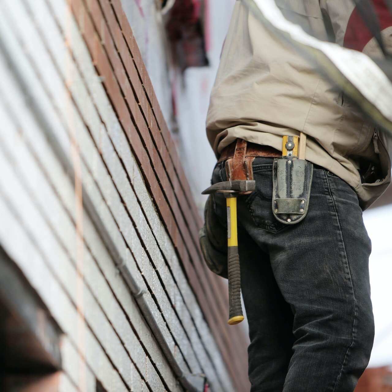 man-with-tool-belt-standing-on-platform